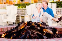 Couple sitting by a fire pit.
