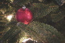 red glittery ornament on a Christmas tree 