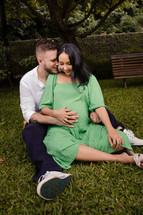 expecting couple sitting in grass