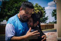 A girl and her pastor embrace after being baptized.