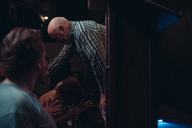 A pastor praying for and laying hands on a member of his congregation.
