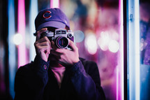 a man taking a picture with a camera at night 