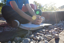 teen boy praying on railroad tracks 