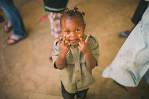 young boy in Kenya giving peace signs 