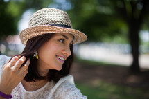 brunette woman in a straw hat outdoors 