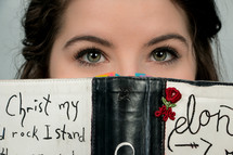 eyes of a teen girl looking over a book 