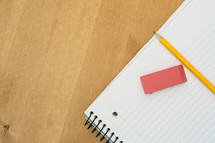 eraser and pencil on a spiral notebook 