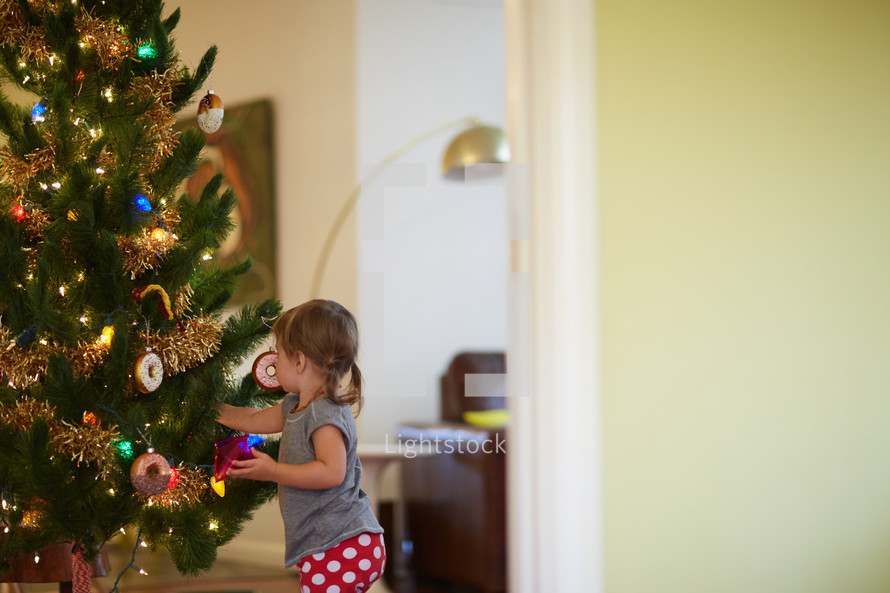 a girl decorating a Christmas tree