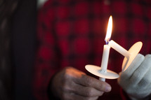 Hands lighting candles at a candlelight service