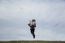 woman standing in a jetpack, figuring out how to get to Heaven 