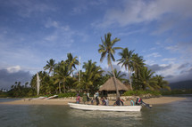 tourists on a boat tour approaching an island