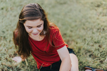 teen girl sitting in a field 