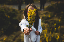 a girl holding picked flowers 