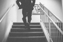 A man running up stairs in a tuxedo 