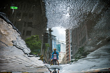 reflection in a puddle of a man on a motorcycle 