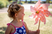 a toddler girl holding a pinwheel 