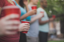 friends holding red solo cups at a gathering 