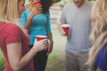 friends in conversation holding red cups at a party 