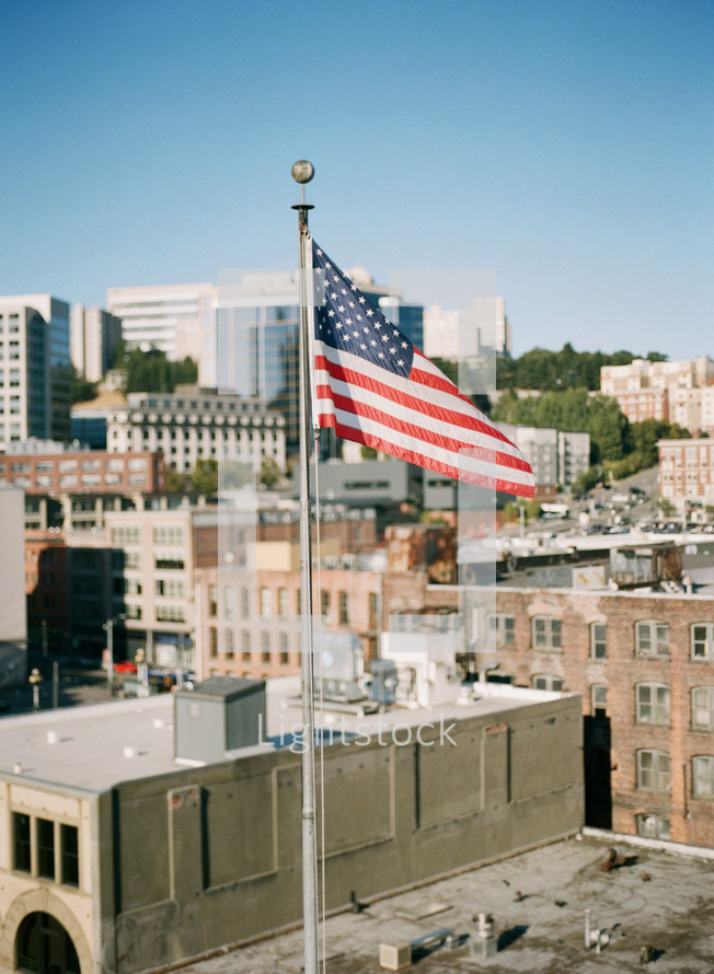 American flag flying above a city