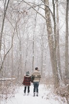 a couple standing outdoors in the snow 