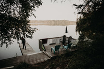 man standing on a dock at a lake 