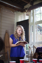 woman reading a  Bible to a group at a Bible study 