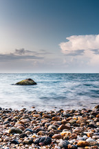 rock in the ocean along the shore 