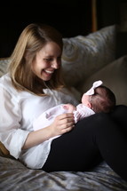 Smiling woman holding her infant daughter in her lap.