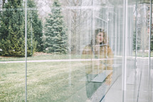 reflection of a woman standing in a window 