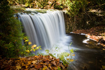 A beautiful waterfall highlights fallen leaves on an autumn day. (4 second exposure)
