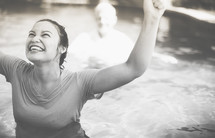 woman with raised hands after a baptism 