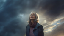 Older caucasian woman looking up at the sky. 