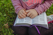 child with a Bible on her lap 
