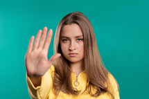 Uninterested lady disapproving with NO hand sign gesture. Denying, rejecting, disagree. Portrait of young woman on blue background, timeout concept. High quality