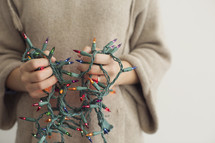 a man holding tangled Christmas lights 