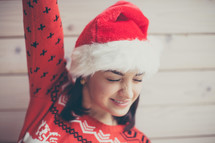 a woman in a Santa hat and Christmas sweater 