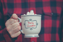 a man holding a mug of hot chocolate 