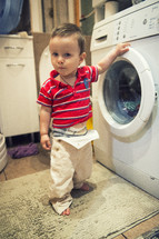 toddler boy in the laundry room 
