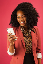 businesswoman looking at a cellphone screen smiling 