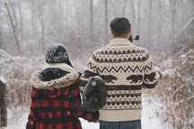 a couple outdoors in falling snow 