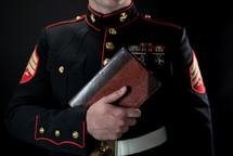 a marine holding a Bible against his chest 