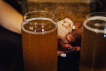 a couple holding hands at a bar 