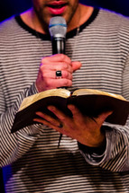 Man reading the Bible into a microphone.