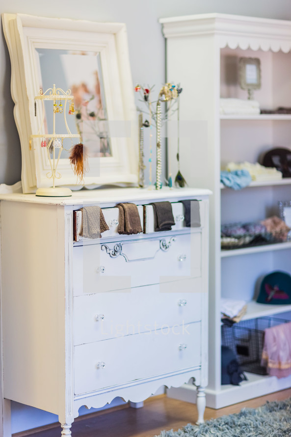 Girl's bedroom with white dresser, jewelry, socks, book shelf mirror