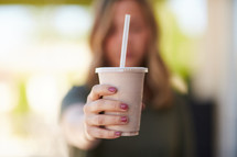 a woman drinking a smoothie 