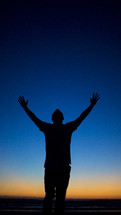 silhouette of a man with raised hands 