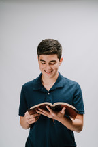 a tee boy reading a Bible 