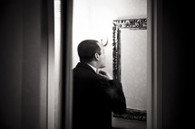 groom getting ready in the mirror
