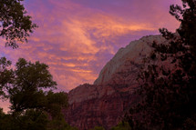 red rock mountains at sunset and pink and purple clouds in a sky 