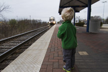 toddler boy watching an approaching train 